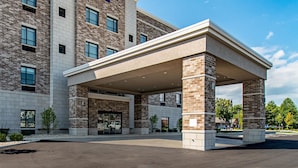 Un hotel Comfort Suites con entrada cubierta y fachada de ladrillo.