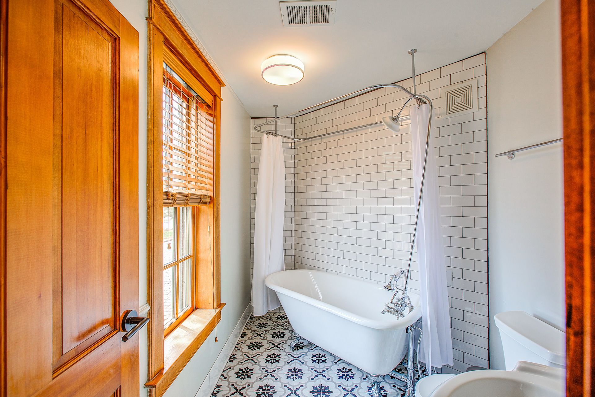 A bathroom with a clawfoot bathtub, a white sink, and a shower with a curtain.