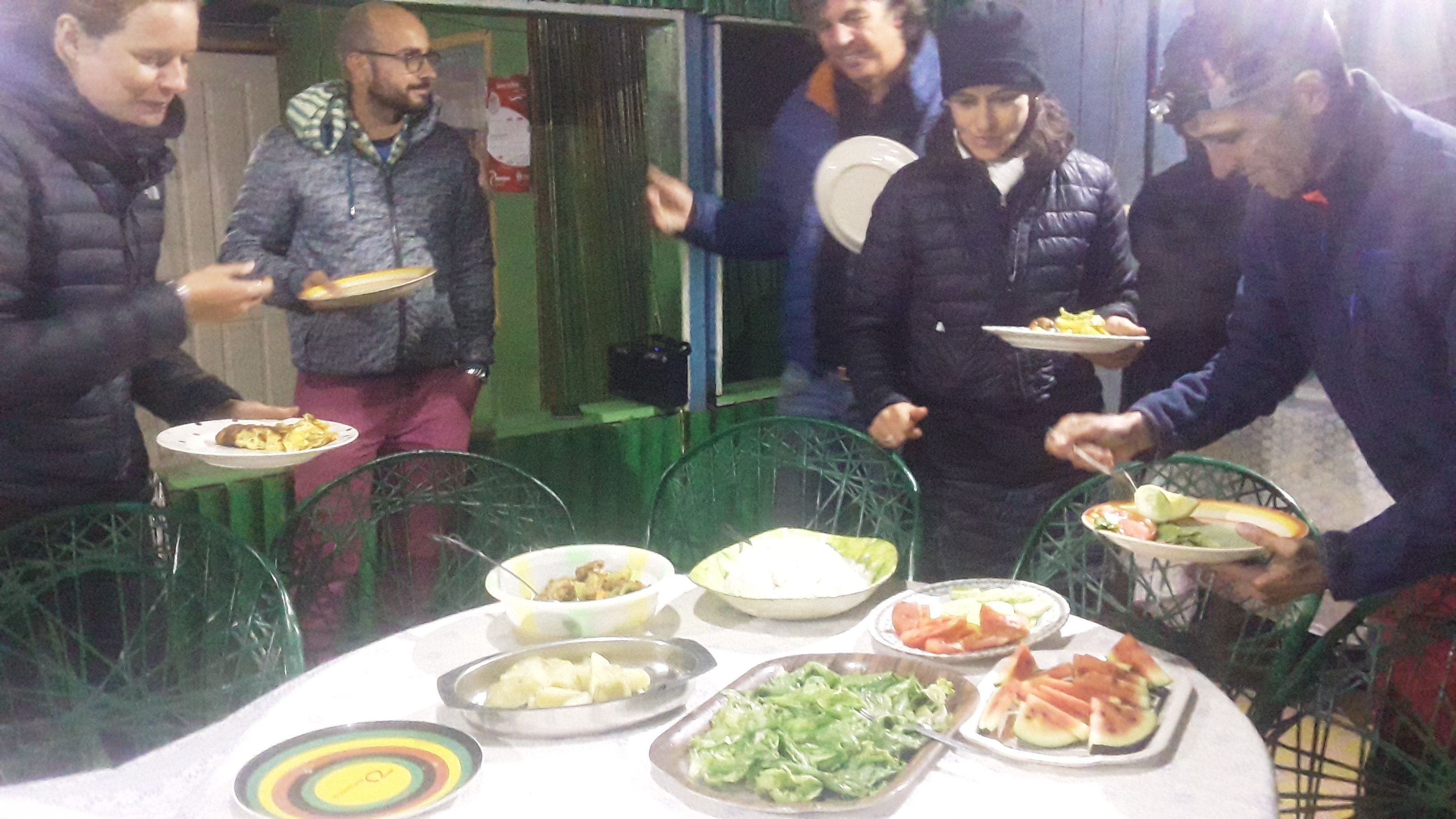 Um grupo de pessoas reunido em volta de uma mesa com diversos pratos.