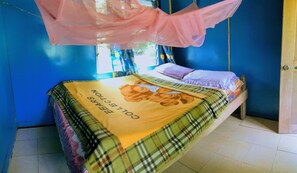 A bed with a plaid bedspread and a canopy. - Quarumanu Area (Tanna Island)
