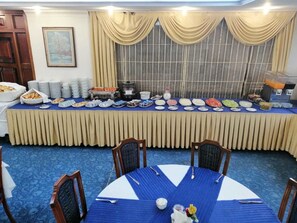 A buffet setup with various food items and a coffee machine. - Hotel Akyuz (Ankara)