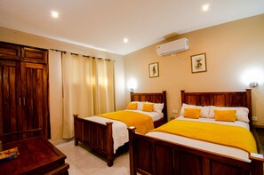 Two comfortable beds, a wardrobe, and a small table make this room a convenient retreat.