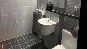 A modern bathroom with a shower, sink, and toilet. - Renaissance Hotel - Hostel (Jeju City)
