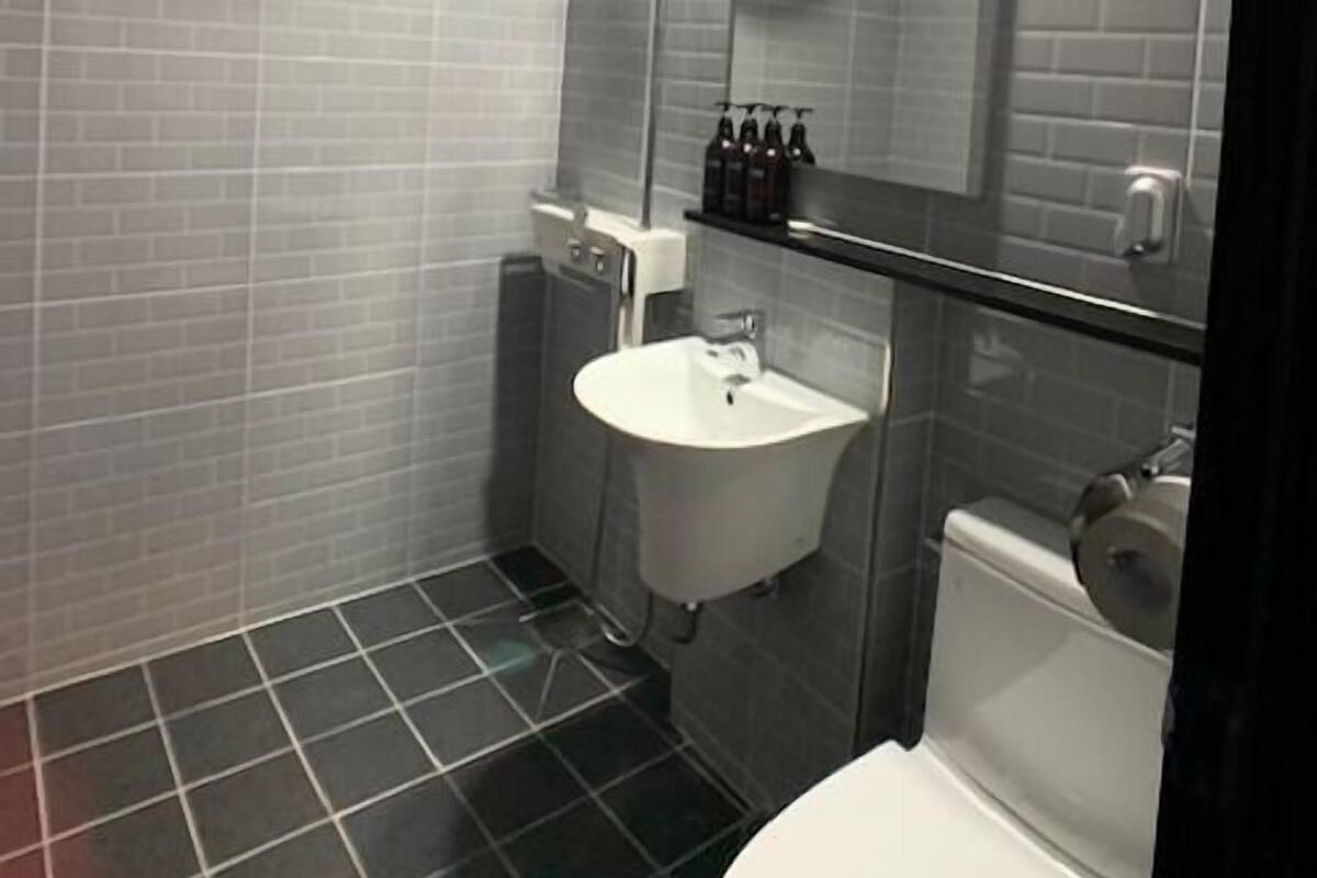 Et moderne badeværelse med bruser, vask og toilet.