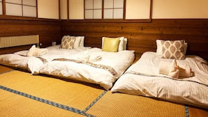 A traditional Japanese-style room with tatami mats, wooden headboards, and shoji screens. - Raicho Lodge Madarao (Iiyama)