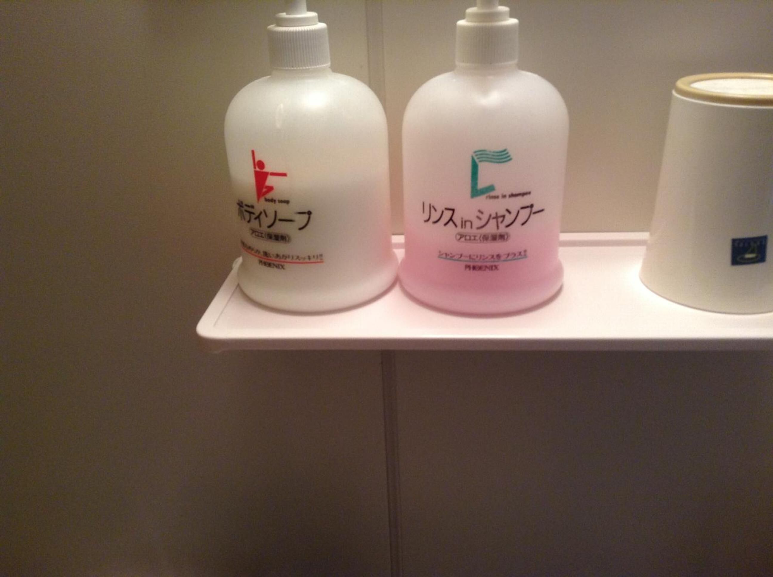 Two bottles of body wash on a white shelf.