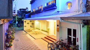 A hotel with a sign reading "Ing Wang Hotel" and a courtyard with bicycles parked outside. - Ing Wang Hotel (Tainan)