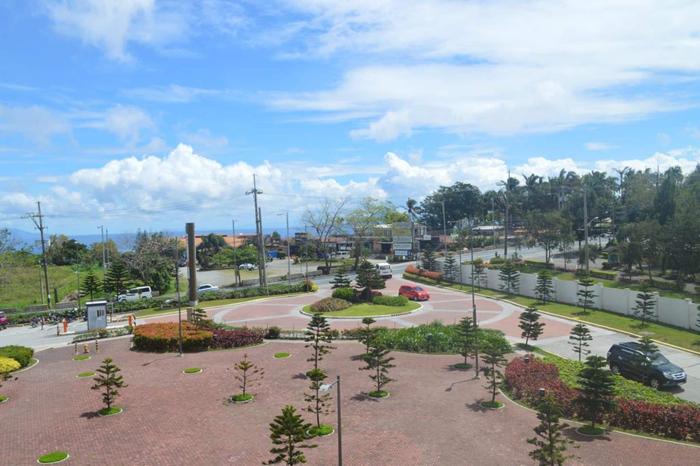 A landscaped area with a roundabout, paved walkways, and greenery.
