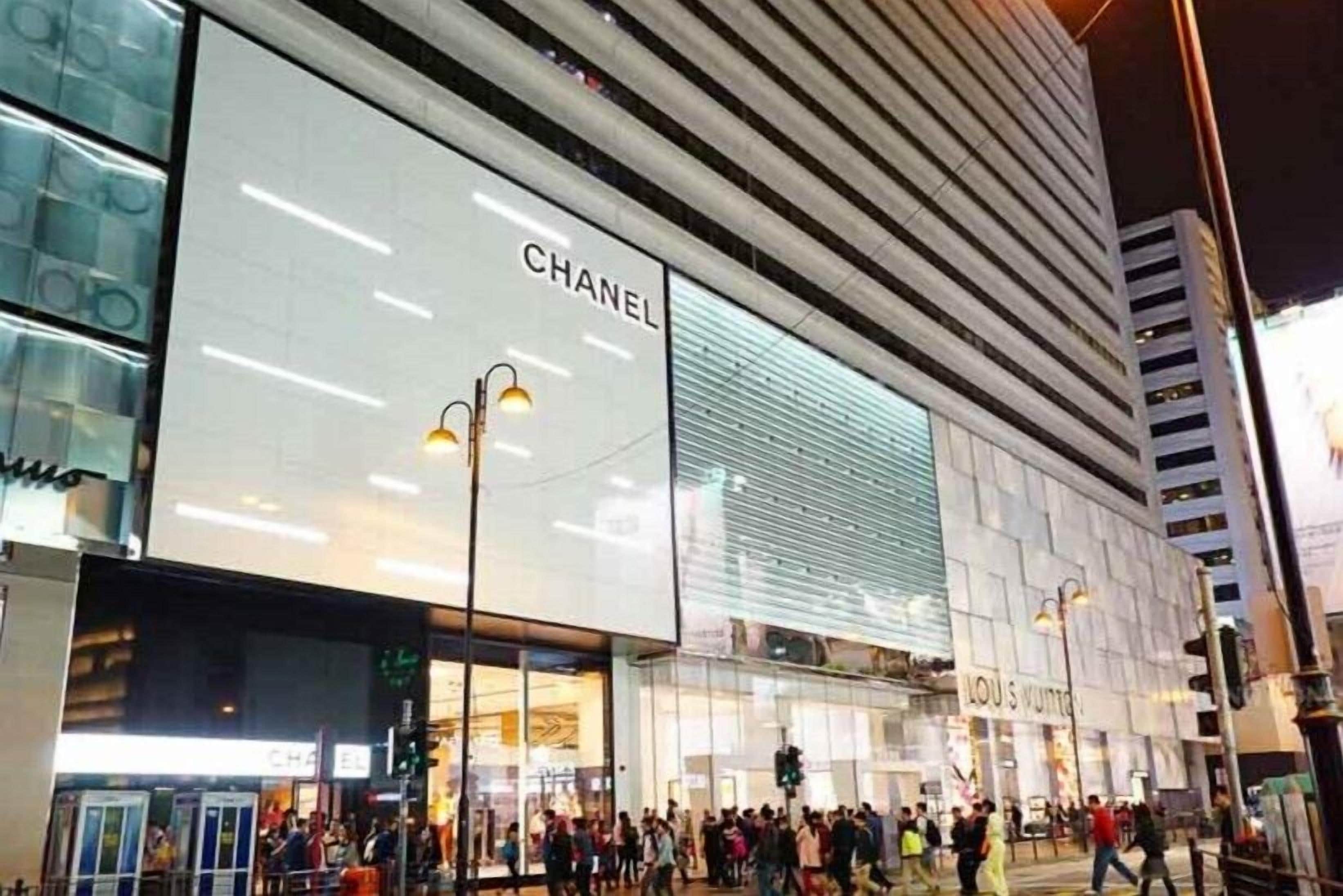 Un edificio moderno con un llamativo letrero de 'CHANEL' en la fachada.