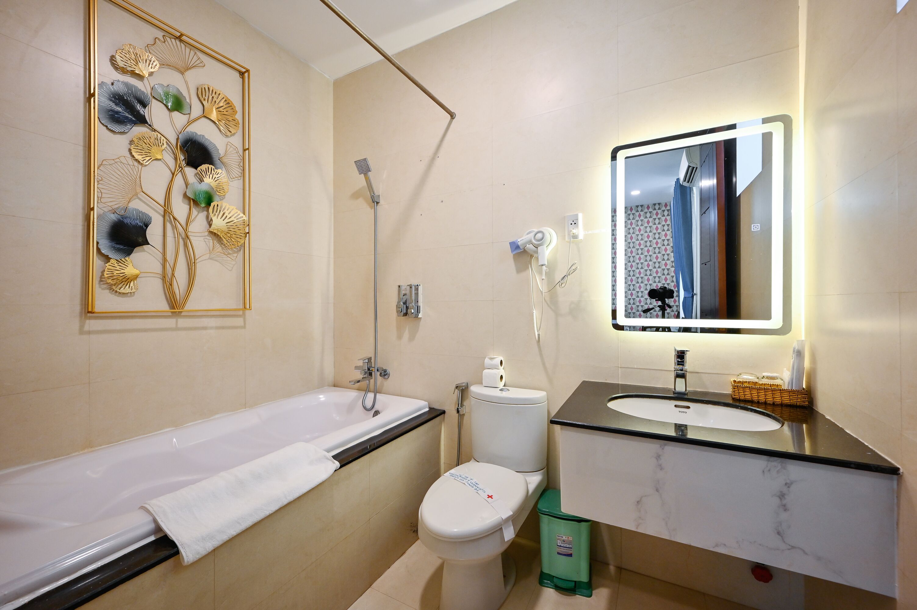 Een moderne badkamer met een bad, toilet en wastafel.