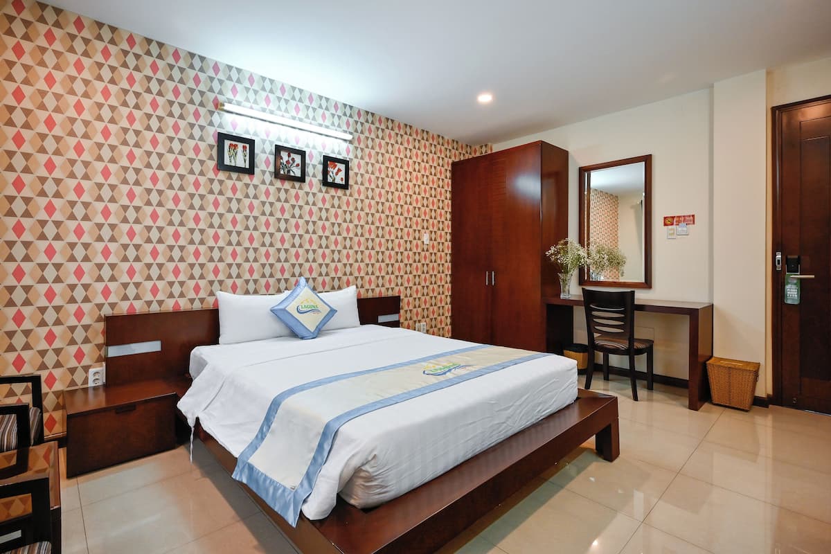 Een hotelkamer met een groot bed, een bureau, een stoel en een kledingkast.