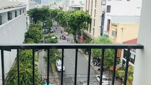 Eine Stadtstraße mit Gebäuden, Fahrzeugen und Fußgängern.