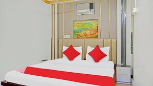 Ein Hotelzimmer mit einem Bett, einem Bild an der Wand und einem weißen Klimagerät.