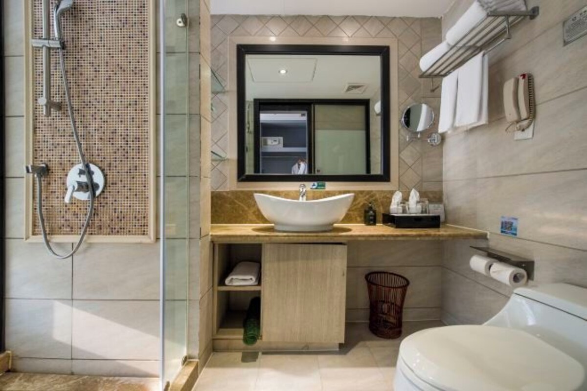 Un baño moderno con un lavamanos grande, un espejo, una ducha y un inodoro.