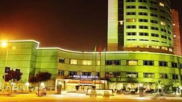 Un hotel de varios pisos con una fachada curva destacada y señalización iluminada en la parte superior.