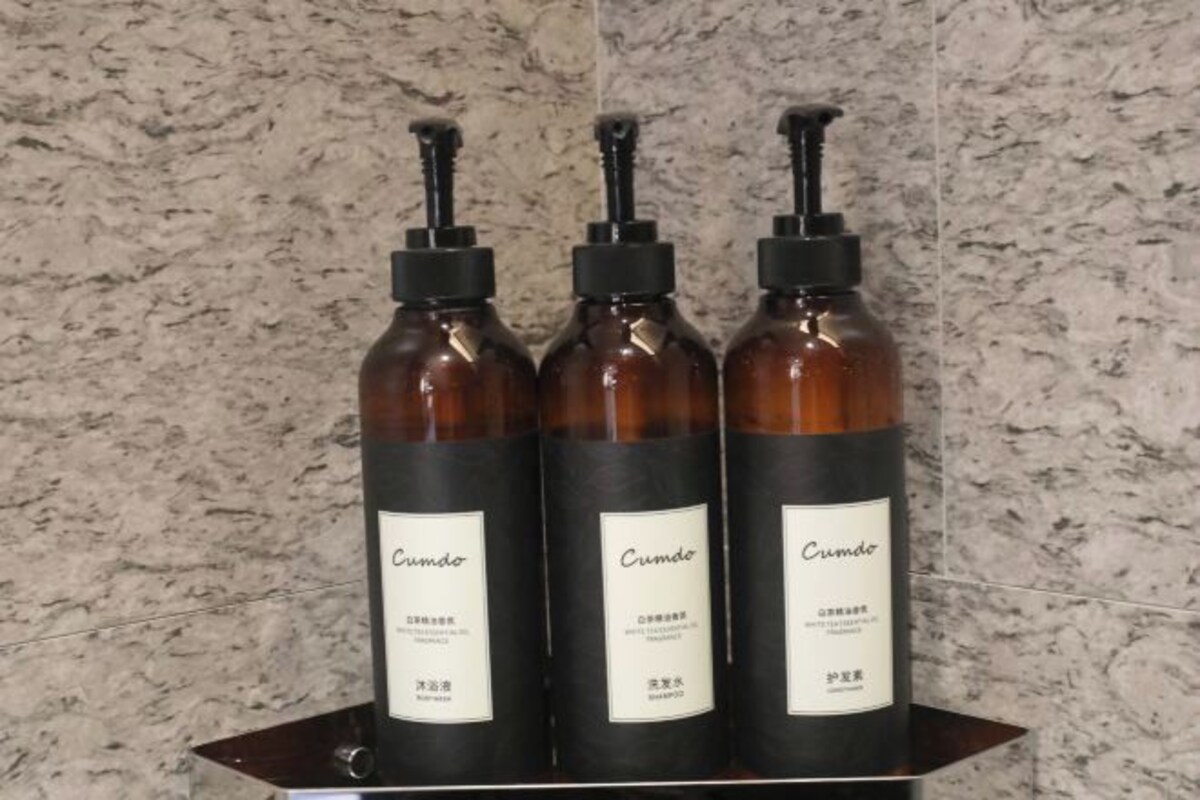 Tres botellas de jabón líquido Cumbre sobre una estantería.