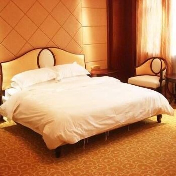 Una habitación de hotel con una cama grande, una silla y una alfombra estampada.