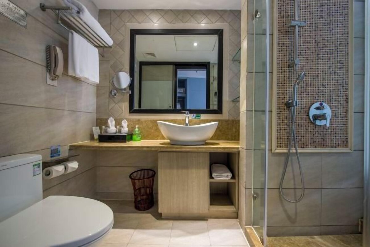 A modern bathroom with a large sink, toilet, and shower area.