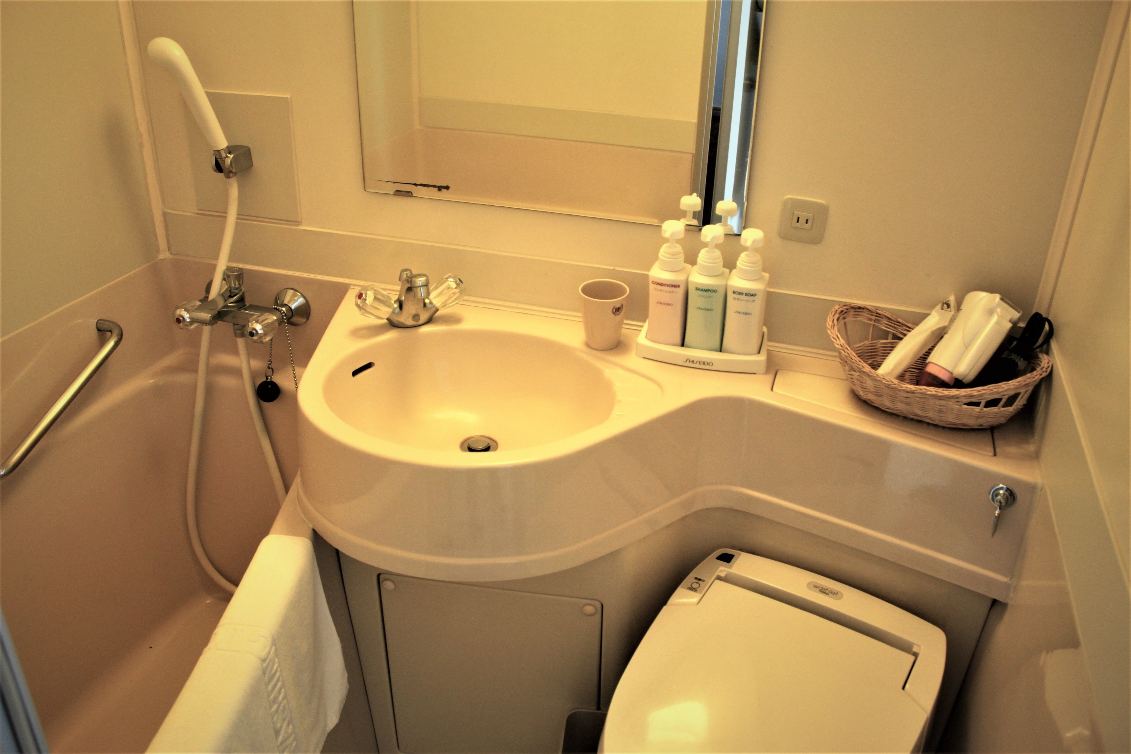 A bathroom with a sink, mirror, and toiletries.