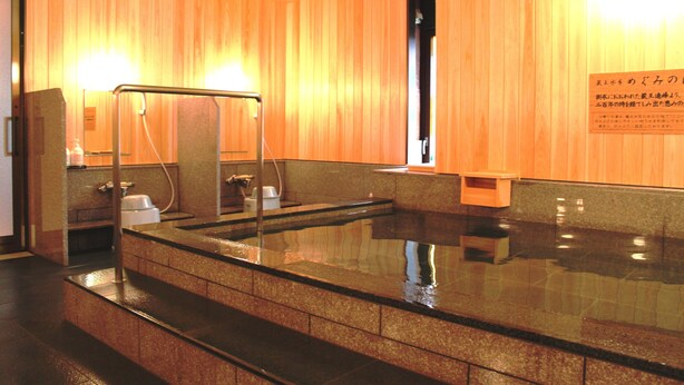 Un onsen japonais traditionnel, avec des murs en bois et un bain en pierre.