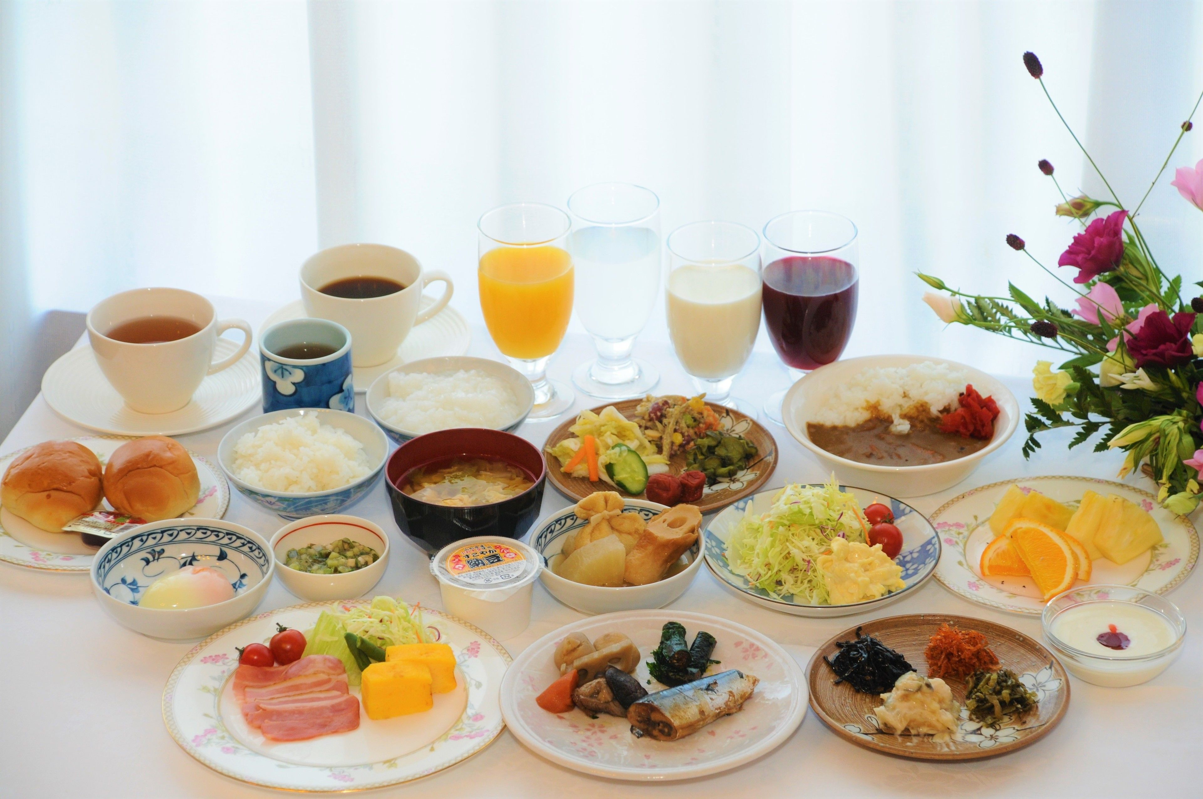 A breakfast table with various dishes and drinks.
