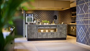 A modern kitchen with a built-in island, a microwave, and a sink. - Postboutique Hotel (Wuppertal)