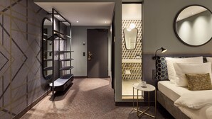 A modern hotel room with a bed, a round mirror, a small table, and a built-in wardrobe. - Postboutique Hotel (Wuppertal)