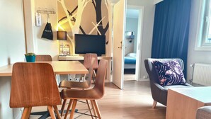 A modern living space with a dining area, a sofa, and a TV. - City Living Sentrum Hotell (Trondheim)