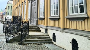 A yellow building with large windows and a stone staircase leading to the entrance. - City Living Sentrum Hotell (Trondheim)
