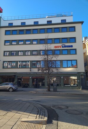 A multi-story building with a 'CITY LIVING' sign, a 'POLE' sign, and a storefront with a visible entrance. - City Living Sentrum Hotell (Trondheim)