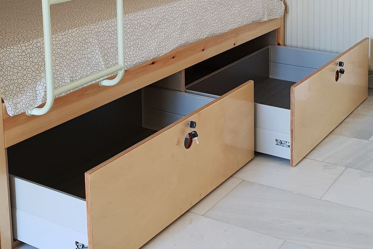 A bunk bed with storage drawers and a ladder.