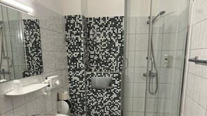 A bathroom with a sink, toilet, and shower. - easy&cosy Hotel Moers (Moers)