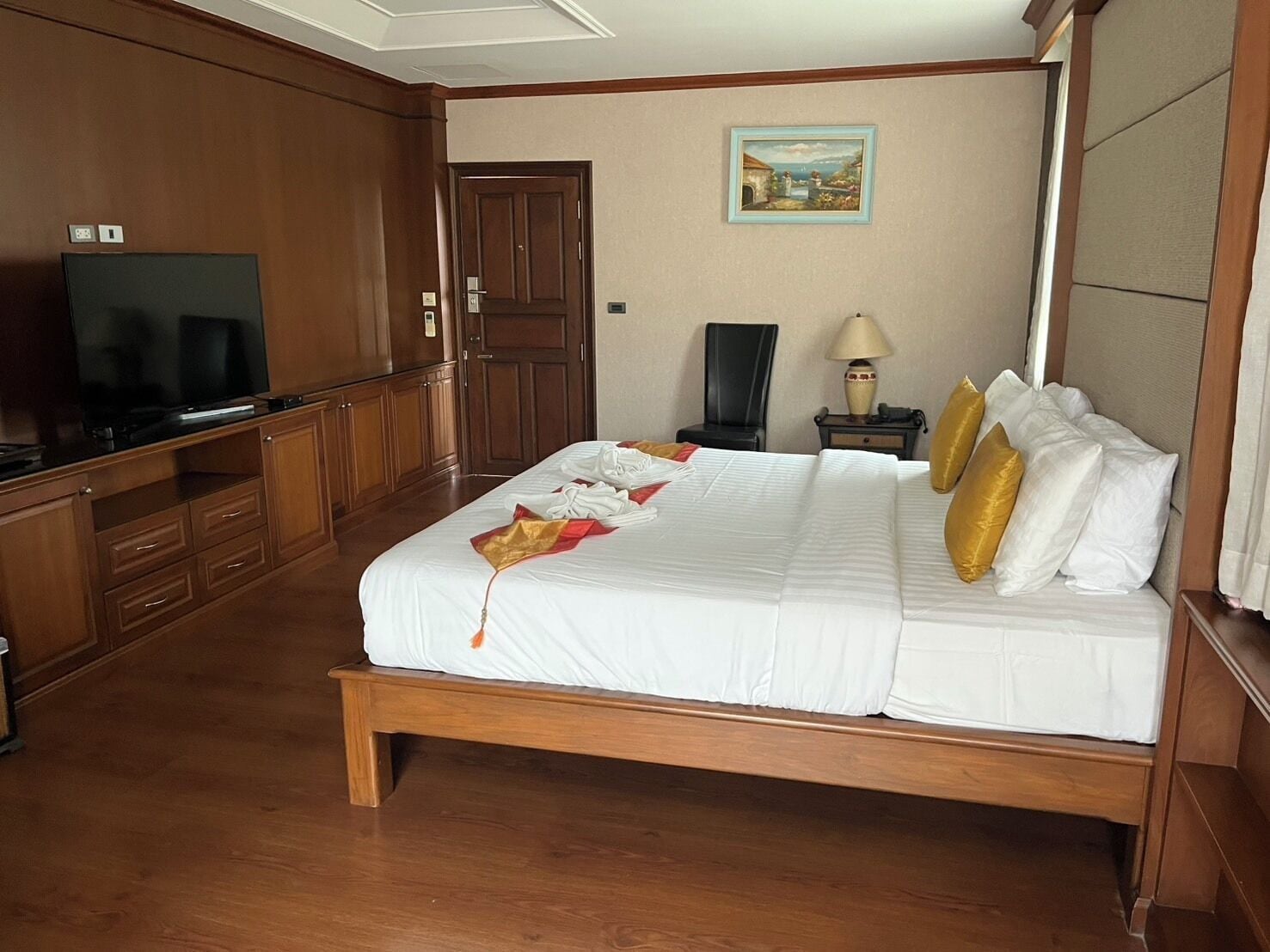 A hotel room with a bed, a television, a desk, and a chair.