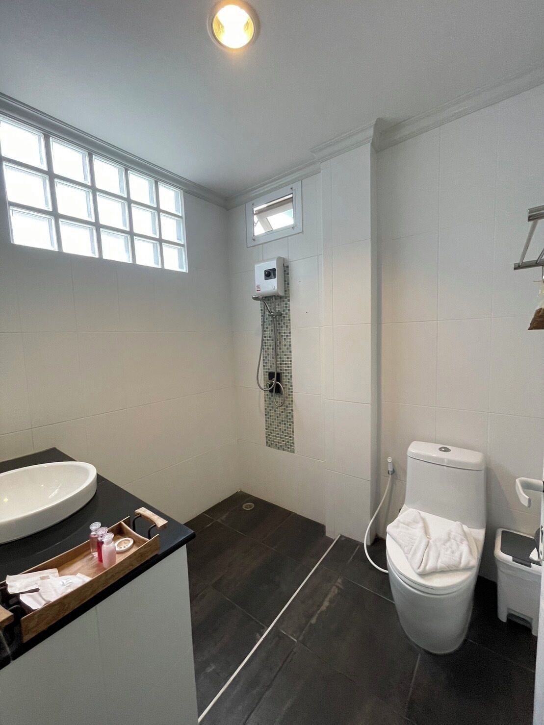 Une salle de bain moderne avec un grand lavabo, une douche et des toilettes.