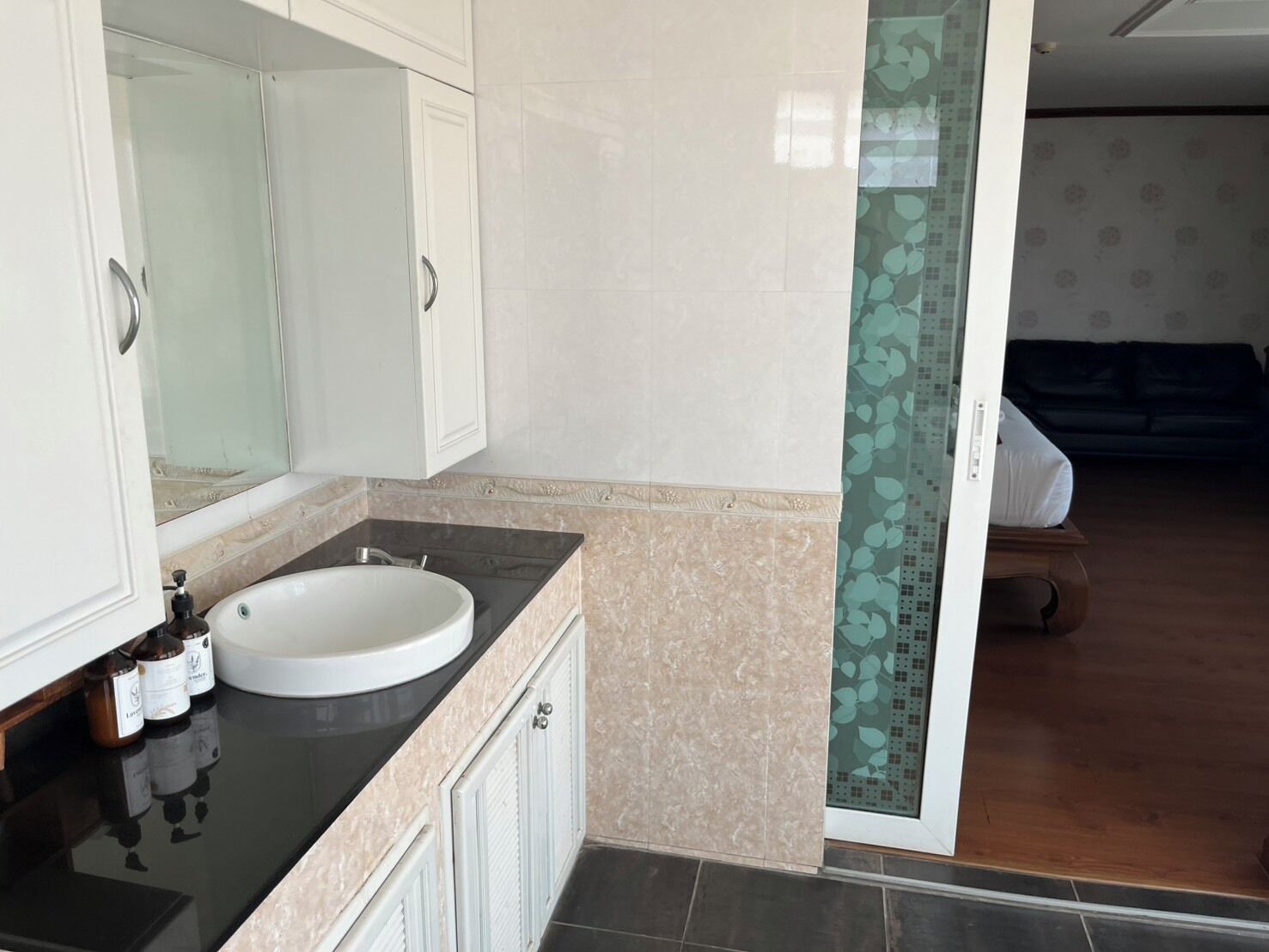 A bathroom with a white sink, a mirror, and a cabinet.
