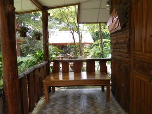 Relax in a serene outdoor space with a comfortable bench amidst lush greenery and a scenic view.