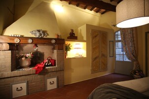 Una stanza accogliente con camino, un letto e una finestra con tende.
