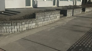 Un edificio moderno con base de ladrillo y fachada de metal.
