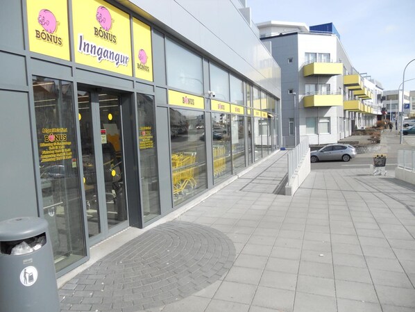 A modern building with large glass windows and yellow signage reading "BONUS Inngangur."