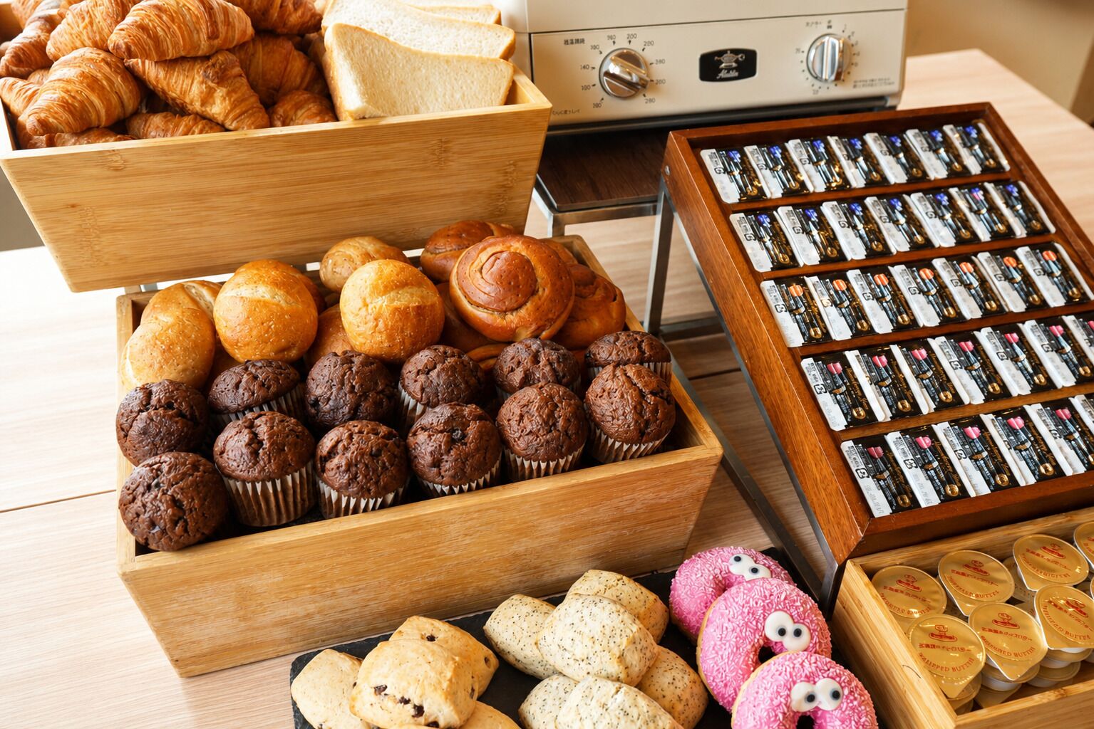 Verschiedene Backwaren wie Gebäck, Muffins und Kekse in Holzkisten.