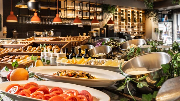 Un bufé con diferentes opciones de comida y una zona de bar al fondo.