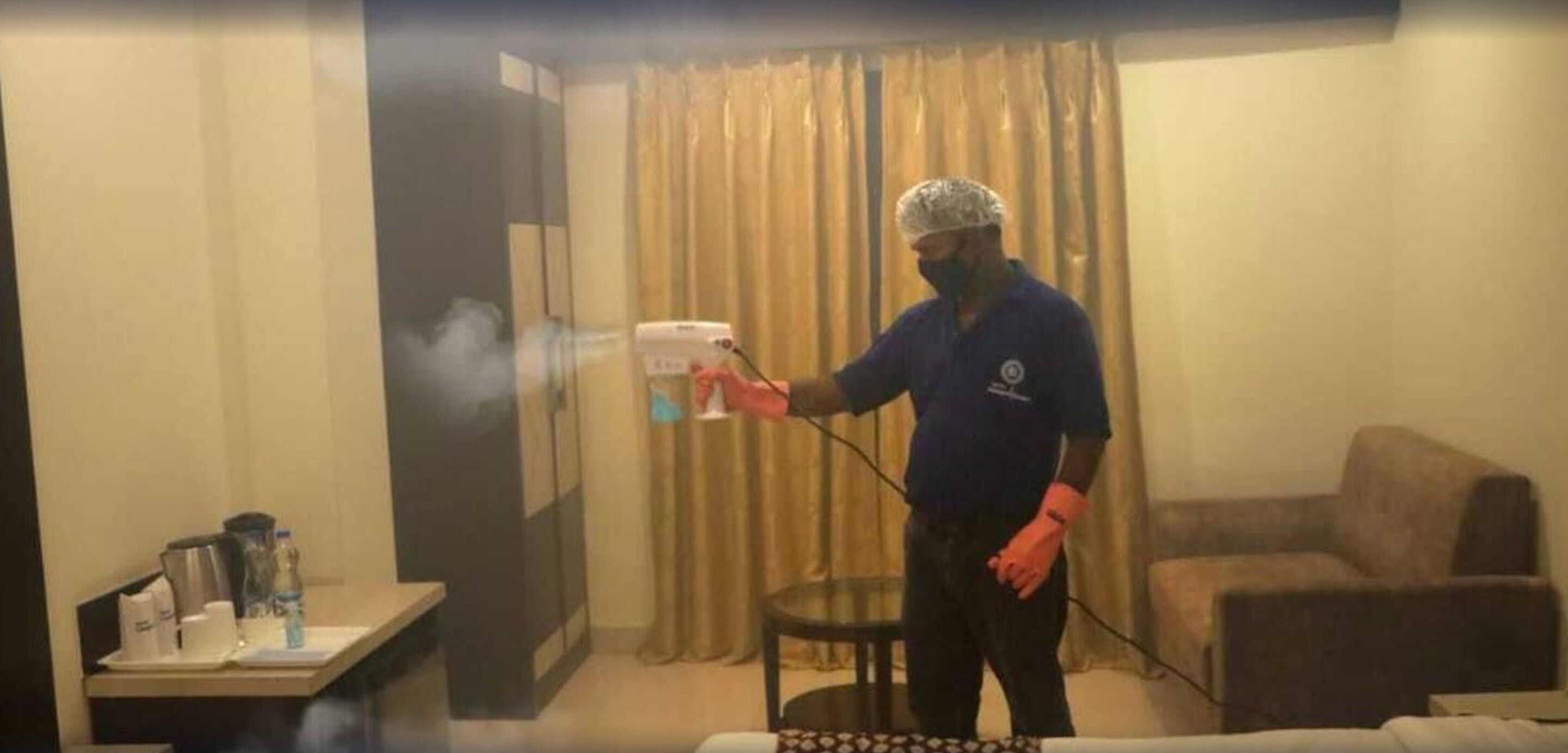 A person cleaning a room with a spray bottle and a cloth.
