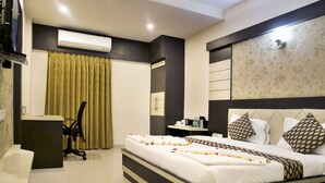 Una habitación de hotel moderna con una cama grande, un escritorio y un aire acondicionado.