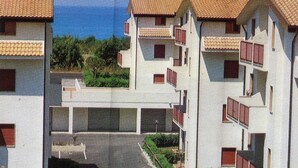 Um bairro residencial com edifícios altos, varandas e uma rua.