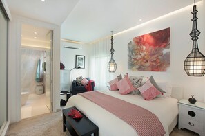 Een moderne slaapkamer met een groot bed, nachtkastjes, een bankje en een kledingkast.