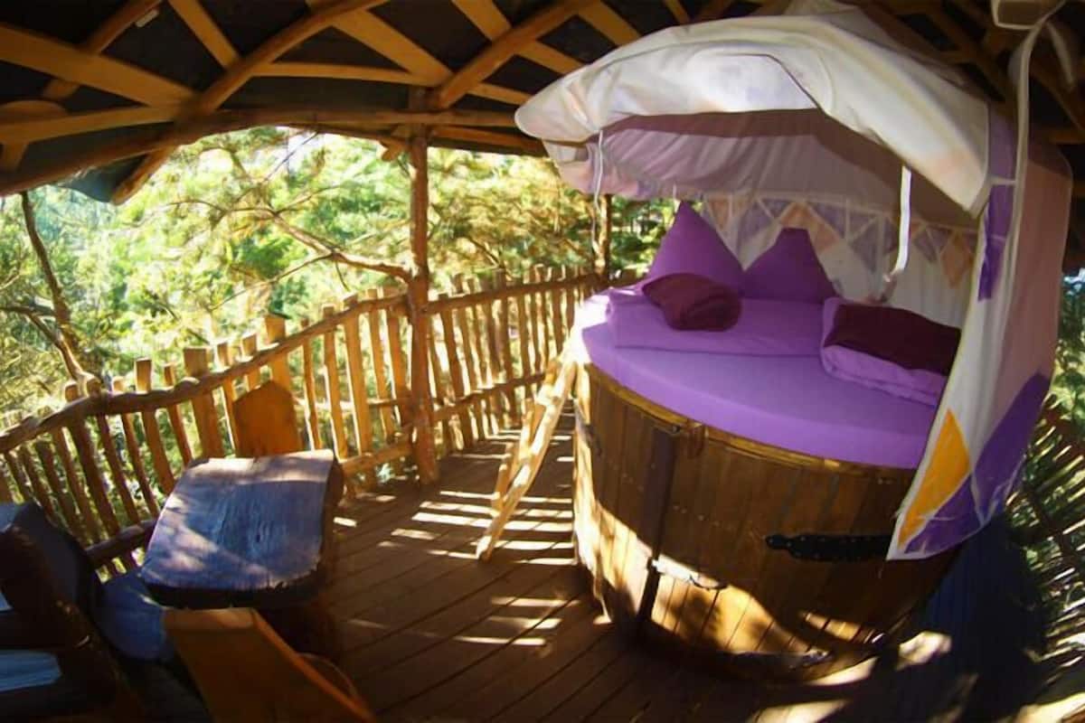 A wooden deck with a bed and a chair.