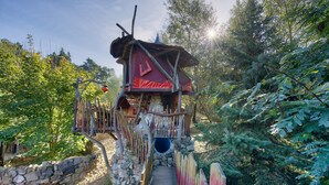A wooden structure with a stone wall and a wooden bridge leading to a tunnel entrance. - Die Geheime Welt von Turisede (Neisseaue)
