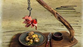Een rustieke houten tafel met een bord eten, een kleine kom en een paar tangen.