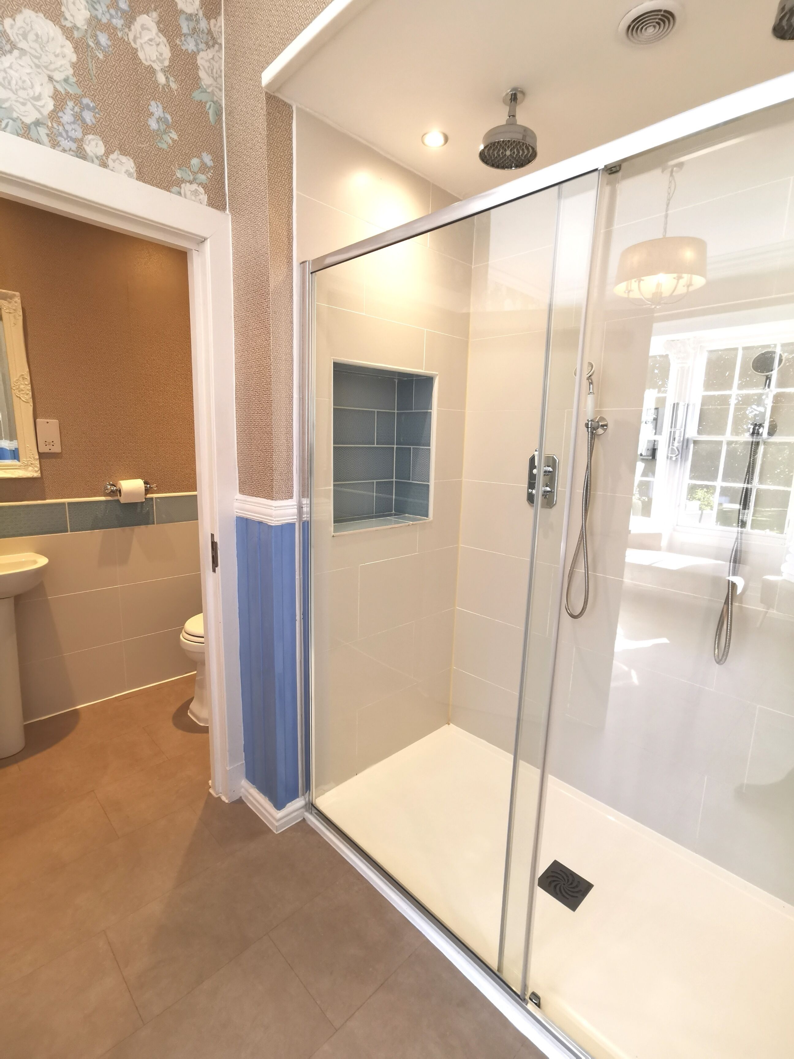 Un baño moderno con ducha envuelta en vidrio, inodoro y lavamanos.