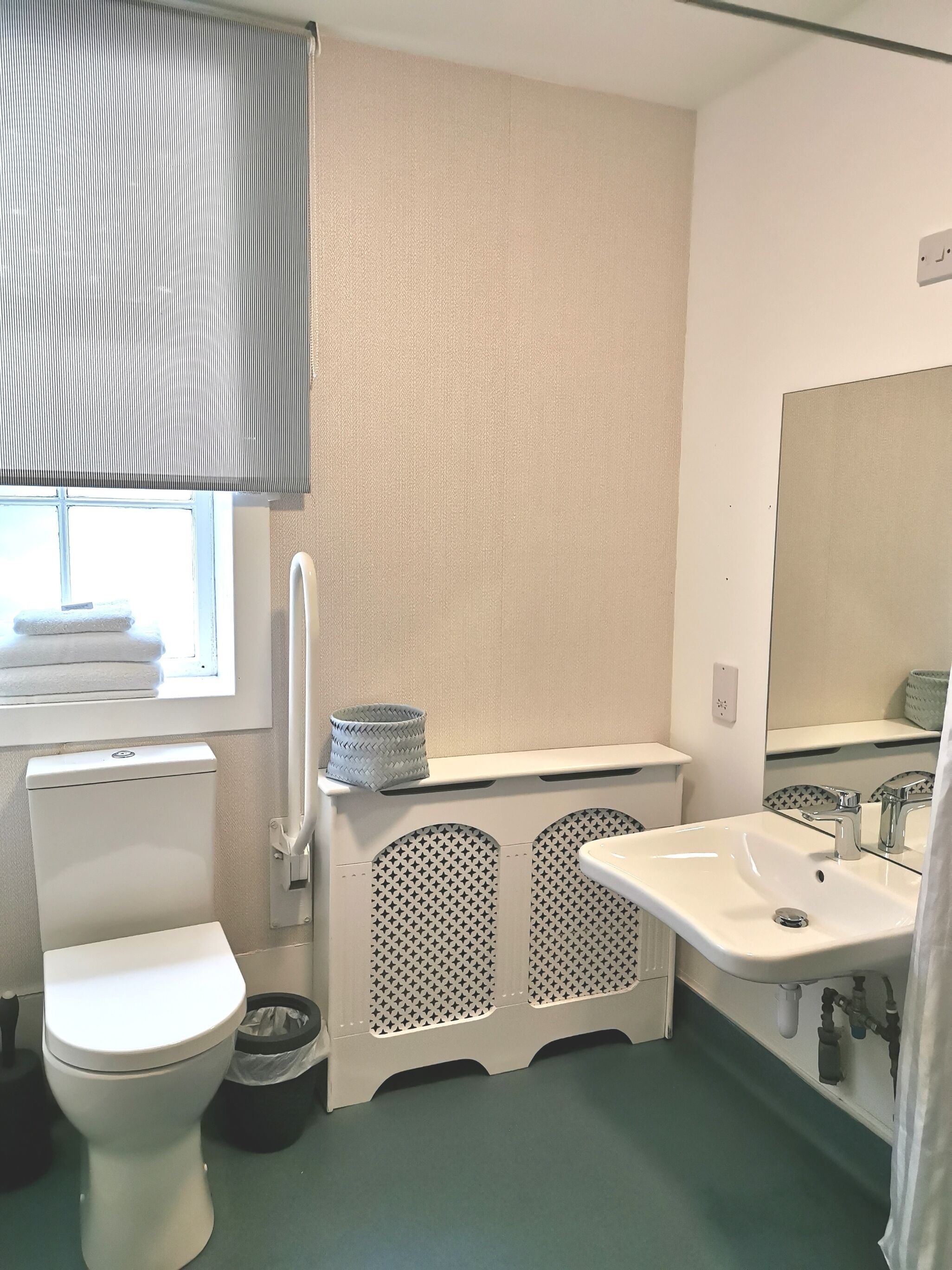 Une salle de bain avec des toilettes, un lavabo et une fenêtre.